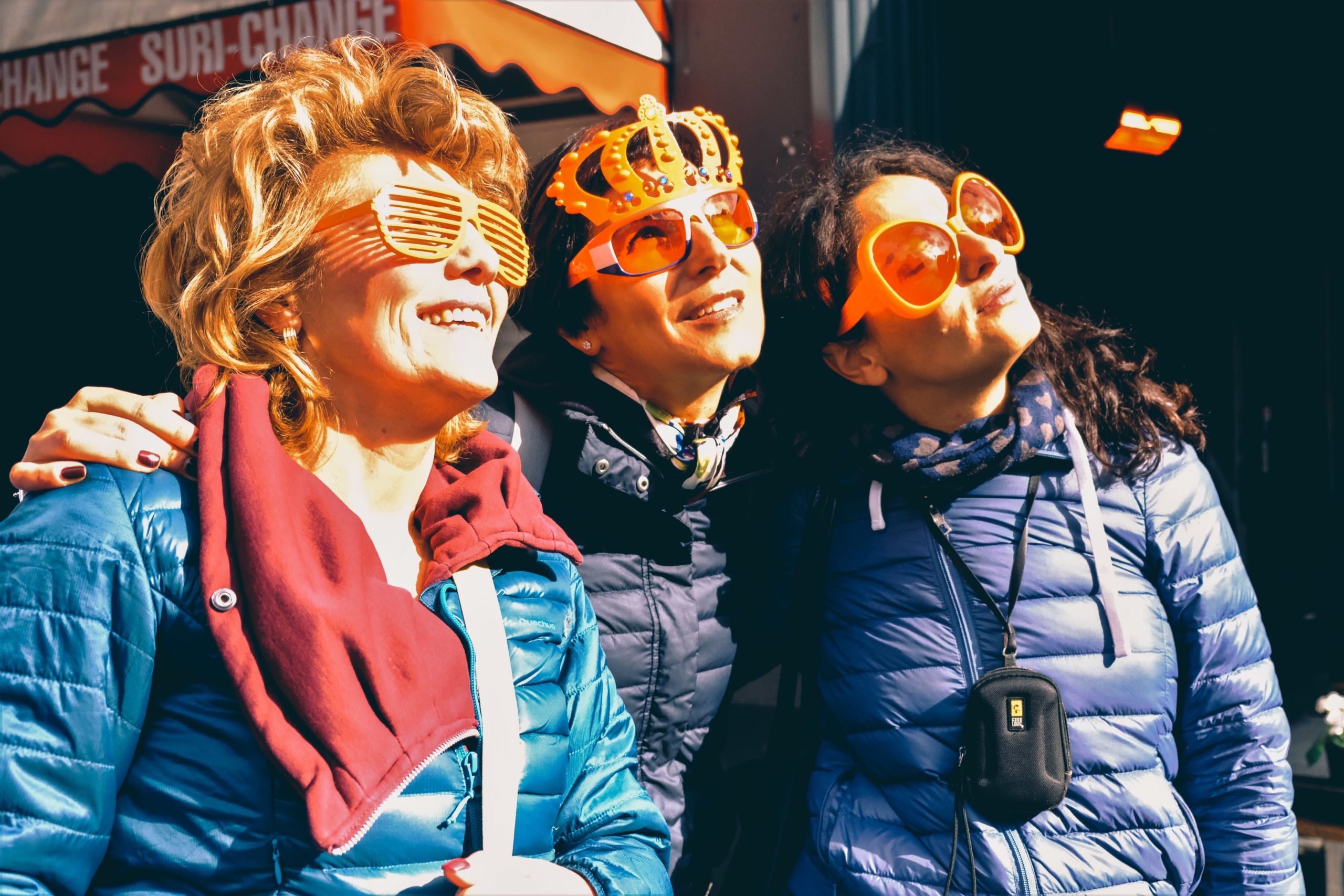 Gruppe von Freunden im Urlaub in Holland, lächelnde Frauen mit lustigen Masken, mit einer festlichen Atmosphäre
